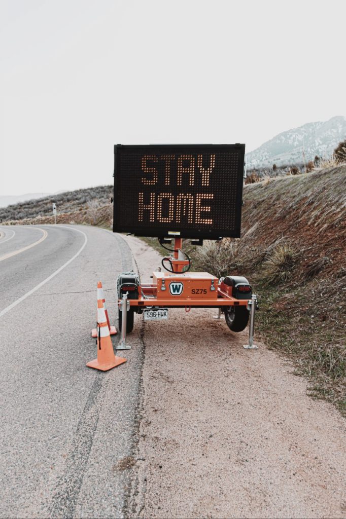 A road sign reads "STAY HOME." Image Credit: Logan Weaver