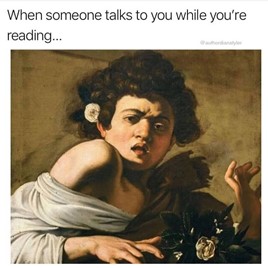 A woman draped in white fabric, with a white flower in front of her and one behind her ear holding back curly dark hair, has her hands up in surprise and a dismayed face. There is text just above the image that reads "When someone talks to you while you're reading..."